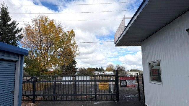 Black metal fence in front of drive-up storage units