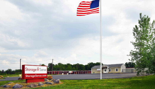 large signage with office and storage facility in the background with large flag pole