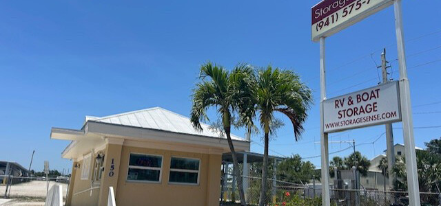 Large sign and palm trees in front of the stairs to enter the office building