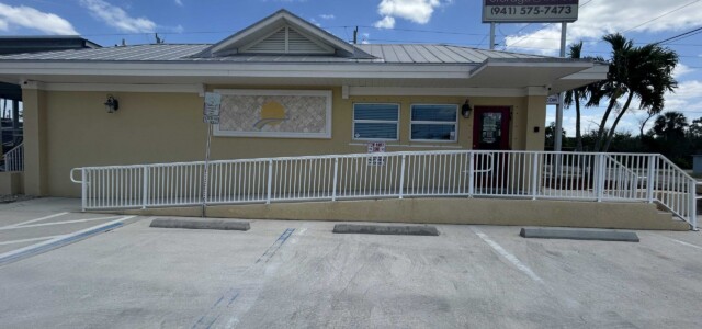 Parking spaces for visitors in front of the wheelchair accessible ramp to the office