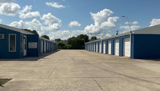 Aisle of drive up blue metal storage units with white doors