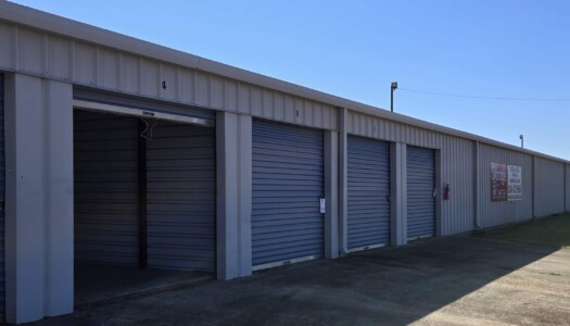 Row of drive-up storage units with one open
